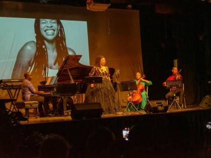 Raehann Bryce-Davis performs alongside musicians Emily Elliott on cello and Jovani Williams on violin.