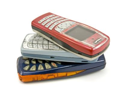This stock photo shows old cellphones stacked on top of each other.