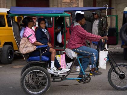 People use a bicycle taxi in Havana, Cuba.