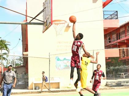 Herbert Morrison Technical High School’s Shamar Russell (left) goes up for a dunk against York Castle High’s J’Dor Griffiths during their ISSA Schoolboy Under-16 Basketball semi-final match at Herbert Morrison Court yesterday