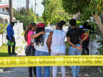 From left: Trudyann Bell Williams, niece; Carol Johnson’s twin sister; Yasheima Bell, niece and Toni-Ann Johnson, niece wait as police conduct investigations at Marlin Way, Braeton, Portmore where their relatives were attacked by a man believed to be of 