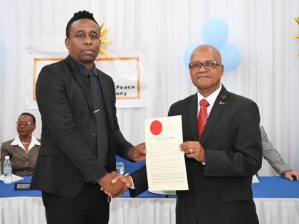 Custos Rotulorum for Portland, Lincoln Thaxter (right), presents Councillor Rohan Vassell with his Instrument of Appointment during the commissioning ceremony for 28 new justices of the peace (JPs), held at Hotel Tim Bamboo in Port Antonio on February 19, 