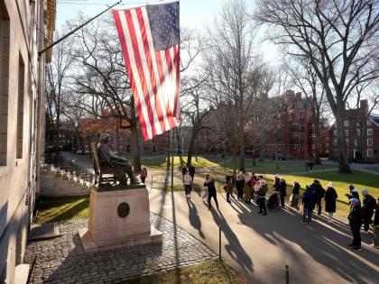 
In this January 2024 photo people are seen taking photos near a John Harvard statue, left, on the Harvard University campus, in Cambridge, Massachusetts.