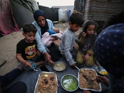 Displaced members of the Al-Zamli family break their fast on the first day of Ramadan inside their tent in Khan Younis, Gaza Strip, Wednesday, February 18.