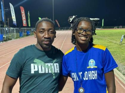 Coach Derol Gardener (left) of Penwood High with his athlete Shakeya Reid minutes after she won silver in the Class 1 100 metres at the recent Corporate Area Championships at the Ashenheim Stadium. 