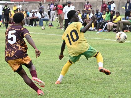 Exceslior’s Matthew Murray (right) sends Wolmer’s Boys’ School’s Nilmar Stewart the wrong way during their ISSA Mighty Malt Urban U16 schoolboy football quarterfinal round game at Wolmer’s yesterday. Excelsior won 3-2 but still missed out on a se