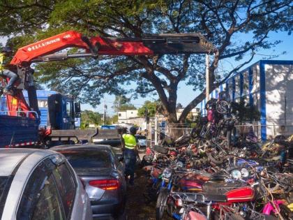 Heavy equipment is being used to remove unclaimed, derelict bicycles and motorbikes on the grounds of the Constant Spring Police Station in St. Andrew during a clean-up day at the facility on February 21.