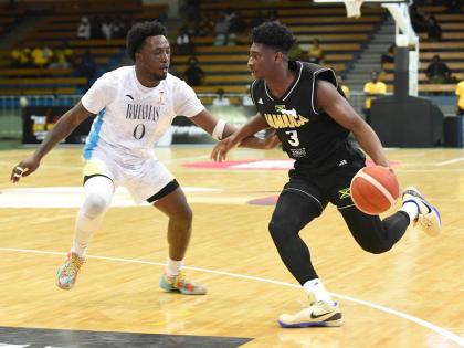 Jamaica’s Andrew Thelwell (right) attempts to get around Garvin Clarke of The Bahamas  during their FIBA World Cup Basketball Qualifier at the National Indoor Sports Centre last night. 