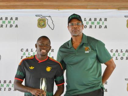 World 100 metres champion and Calabar old boy Oblique Seville (left) poses with his Lionheart Award for Courage. It was presented to him by Karl Thompson, president, Calabar Alumni Florida.