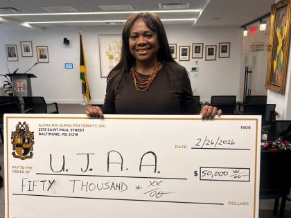 Debbie Mercer-Miller shows of the cheque to be donated the to three hurricane-affected schools. 