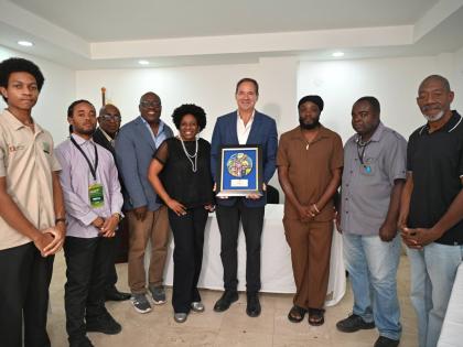 Hotelier Christopher Issa, owner and operator of S Hotels Jamaica, poses with a plaque he was honoured with by media members of the Western Jamaica Media Association (WJMA) on Sunday at Hotel 39 in Montego Bay. He is flanked by WJMA members. 