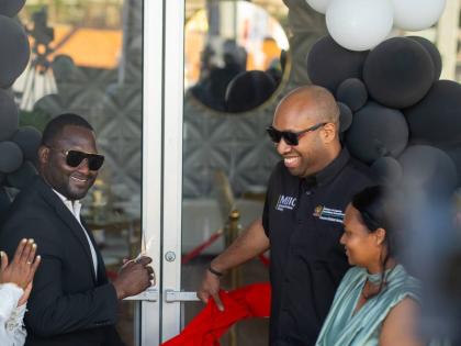 Delano Seiveright (centre), state minister in the Ministry of Industry, Investment and Commerce, joins Richard Cole and Taquilia Chin‑Cole in cutting the ribbon at the formal opening of Level 8 - Bakery, Dining and Gaming Lounge at 6 North Street in Blac
