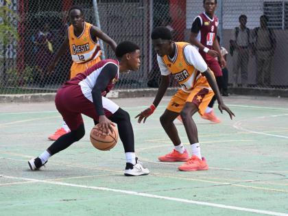 Herbert Morrison Technical High’s Antonio Kerr (left) tries to dribble around Manchester High’s Wasim Windett during Game 1 of the ISSA Schoolboys Under-16 Basketball finals at Herbert Morrison’s court on Monday, March 2.