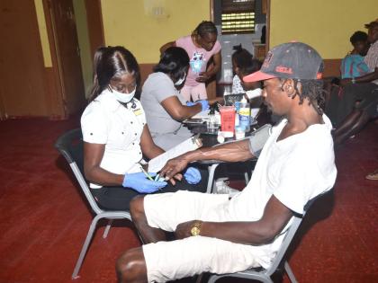 Representatives of St John Ambulance check the vitals of community members at Balaclava in St Elizabeth.