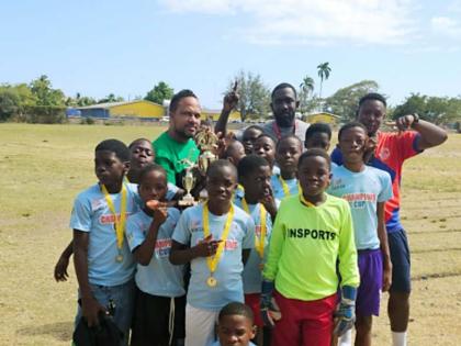Spanish Town Primary School’s principal Roogae Kirlew (left, back row), coach Neriah Barrett (centre, back row) celebrate with the players after their 1-0 win over Old Harbour in the Insports St Catherine Primary Schools football final. Spanish Town won 