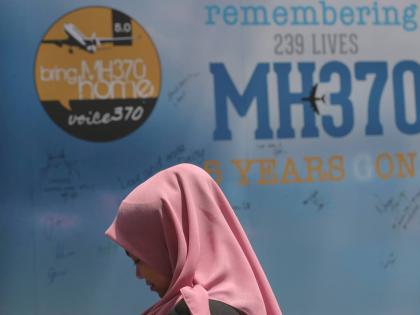A girl stands in front of a condolence message board during a Day of Remembrance for MH370 event in Kuala Lumpur, Malaysia.