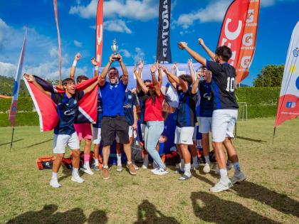 Players and coaches from the International School of Port of Spain celebrate their boys’ championship victory at Soccer Feva 2026 at the American International School of Kingston.