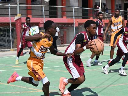 Herbert Morrison Technical High’s Tyler Linton (right) tries to dribble away from Manchester High’s Waine Green Jr during their ISSA Schoolboy Under-16 Basketball Game One at the Herbert Morrison court on March 2.