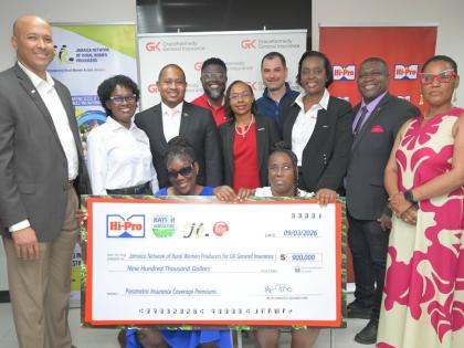 Minister of Agriculture, Fisheries and Mining,  Floyd Green (third left, second row), joins a photo opportunity as Hi-Pro presents a symbolic cheque to members of the Jamaica Network of Rural Women Producers (JNRWP) during the Roots Resilience Parametric I