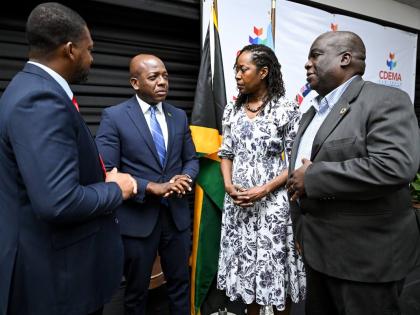 Minister of Labour and Social Security, Pearnel Charles Jr. (second, left), engages in a discussion with Director General at the Office of Disaster Preparedness and Emergency Management (ODPEM), Commander Alvin Gayle (left); Executive Director of the Carib