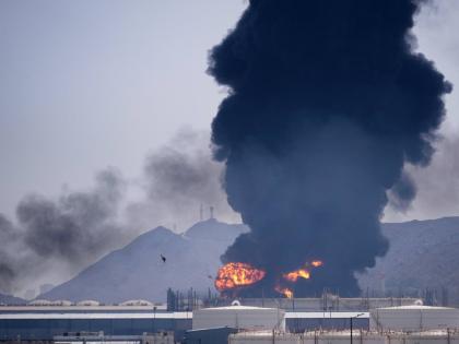 A fire and plume of smoke rise after, according to authorities. debris from an intercepted Iranian drone struck an oil facility in Fujairah, United Arab Emirates on March 14, 2026.(AP Photo/Altaf Qadri)