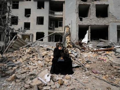 
A woman sits on rubble across from a residential building damaged last Sunday during the US-Israeli air campaign in Tehran, Iran, Thursday, March 12, 2026.