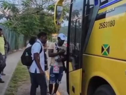 A screenshot from a video showing a man at the entrance to a JUTC bus in Ocho Rios, St Ann collecting money from persons boarding the bus.