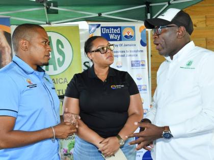 United Way of Jamaica CEO Kerry-Lee Lynch (centre) and Minister of Agriculture, Fisheries and Mining Floyd Green listens as Jamaica Agricultural Society CEO Derron Grant detail the particulars of the first distribution from the UWJ Hurricane Melissa Restor