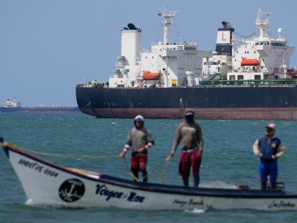 Fishermen pass an oil tanker in the Gulf of Venezuela off the shore of Punta Cardon, Venezuela.