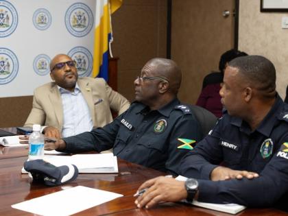 Town Clerk Robert Hill (left) looks on during a recent Kingston and St Andrew Municipal Corporation meeting. 