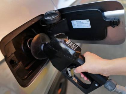 A person fills up her vehicle's gas tank at a gas station in Buffalo Grove, Ill., Thursday, March 19, 2026. 