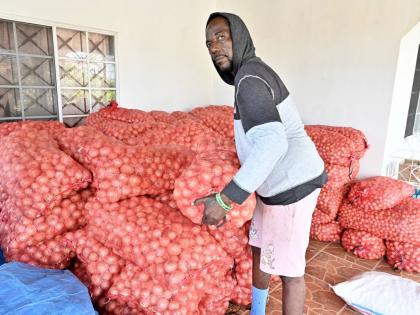 
Kevin Cooper, onion farmer in Heartease, St Thomas, with tons of onions stored on his aunt’s veranda.  