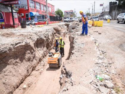Workmen operate a road roller along a section of roadway under the Hagley Park Road Improvement Project in St Andrew in 2018.