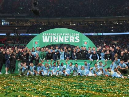 Manchester City players and staff celebrate with the trophy after winning the English League Cup final soccer match between Arsenal and Manchester City in London, Sunday, March 22, 2026. (AP Photo/Richard Pelham)