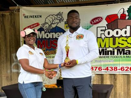 Ramiesh Williams, winner of the David McMorris Cup, collecting his championship trophy  from Karrell Scott, chief executive officer of Money Muss  Games and Bar. 