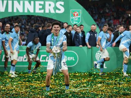Manchester City’s Nico O’Reilly celebrates with the trophy after his team won the English League Cup final match against Arsenal at Wembley Stadium in London yesterday.
