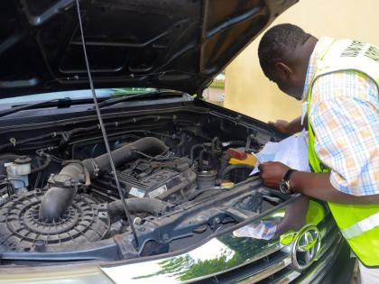 An Island Traffic Authority examiner checks the engine of a vehicle at one of the ITA's service hubs, as part of the fitness certification process.