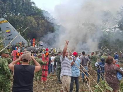 People stand around a military cargo plane that crashed after taking off from Puerto Leguizamo, Colombia, a remote municipality in the Amazonian province of Putumayo, Monday, March 23, 2026.
