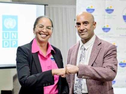 Nicole Adamson, CEO of the Environmental Foundation of Jamaica (EFJ) (left), and Dr. Kishan Khoday, Resident Representative of the UNDP Multi Country Office in Jamaica, share a fist bump after signing a Memorandum of Understanding to scale up climate‑act