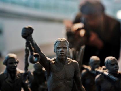 FILE - A man photographs a maquette of a statue, at City Hall, London, Monday, Aug. 18, 2008. 