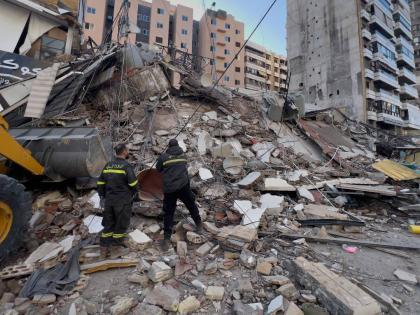Civil defense workers check a destroyed building that was hit by an Israeli airstrike in Dahiyeh, Beirut's southern suburbs, Lebanon, Tuesday, March 24, 2026. 