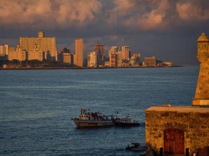 Activists wave Cuban and Palestinian flags from the vessel Maguro, arriving from Mexico with humanitarian aid as part of the "Nuestra America," or Our America Convoy, in Havana Bay, Cuba on March 24, 2026. (AP Photo/Ramon Espinosa)