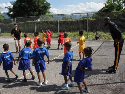 Akira Kanehama, Japan International Cooperation Agency (JICA) volunteer and Timol Stanberry, PE teacher, teaching a group of kindergarten students of Tarrant Primary School, to stretch. 