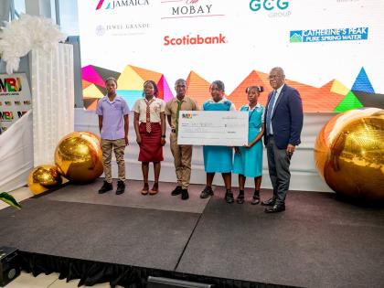 Saluting commitment and endurance: Senator Charles Sinclair (right) shares a photo op with a group of secondary awardees after presenting them with the symbolic cheque for J$30 million during the MBJ Foundation’s Charity Run/Walk Grant Award Ceremony at 