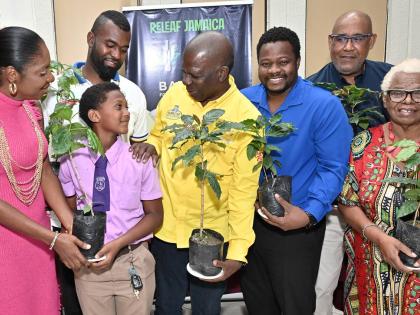 Young cricketer Se’andre Annick Wisdom, (second left) of Ascot Primary School is delighted to accept a coffee seedling as he stands alongside (from left) Andrea Hanson, chairman  of Portmore Sports Association; Aaron Johnson, founder of Blue 52 T20 Relea