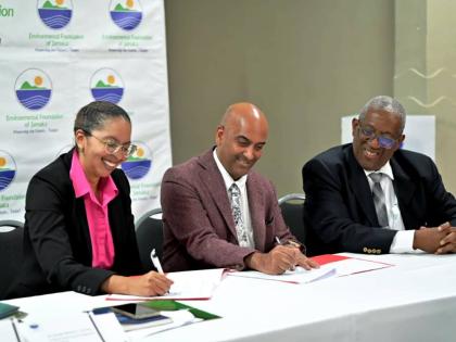 From left: Nicole Adamson, CEO of the EFJ, and Dr. Kishan Khoday, UNDP resident representative, ink the new agreement while Prof. Dale Webber, chairman of the EFJ, shares in the moment.