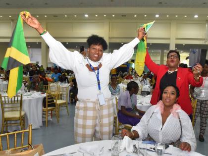 Delegates from Florida, Sandra Christie Brown (left), Georgette Stewart and Dr Rose Marie Lewis (right) waive the Jamaican flag during a presentation at the 10th Biennial Jamaica Diaspora Conference at the Montego Bay Convention Centre in Rose Hall, Monteg