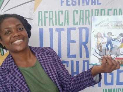 Kadeen Dobbs displays her book, ‘Building Comprehension and Literary Skills In Global Black History for High Schoolers’.