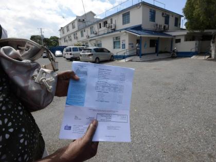
A lady checks her water bill before making payment at the National Water Commissioner office on Marescaux Road, Cross Roads, in 2016.