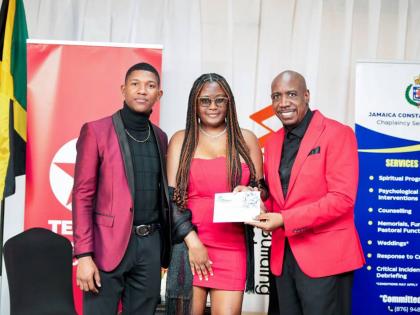 Constable Javaughn Young and Shy-Ann Monteith collect a gift certificate from Deputy Chaplain, Rev Dr Courtney Faulknor at the couple’s retreat. 